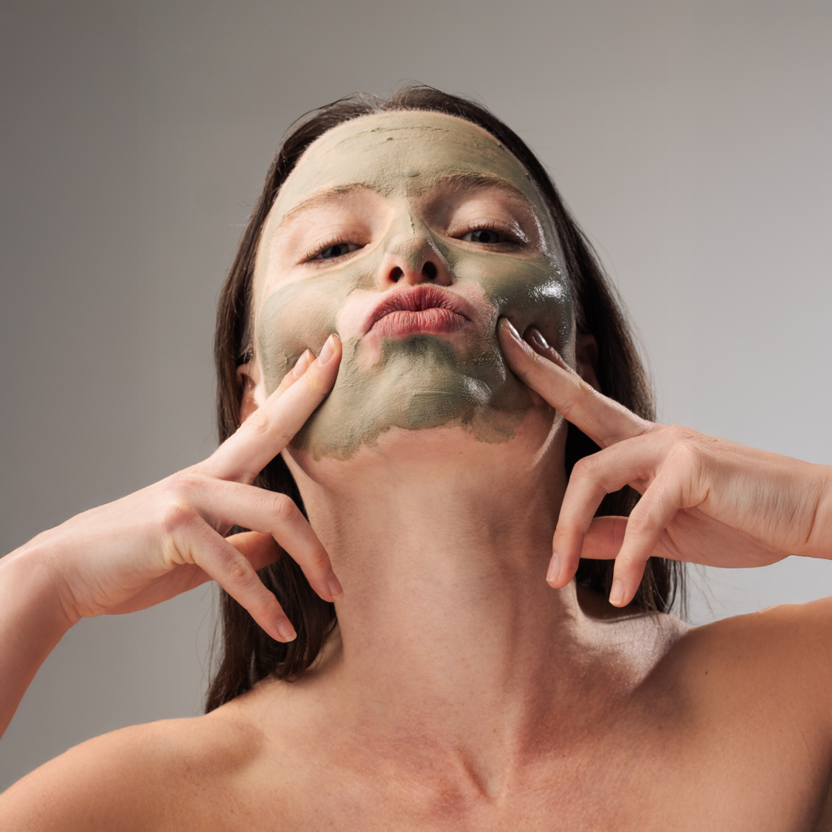 Femme avec de l'argile sur le visage
